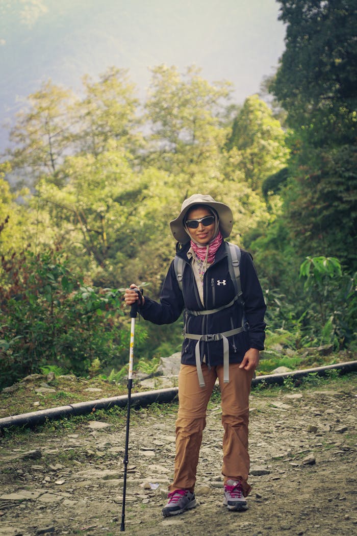 services-03 A woman hiker with trekking gear on the Annapurna trail, enjoying a sunny day in Nepal.